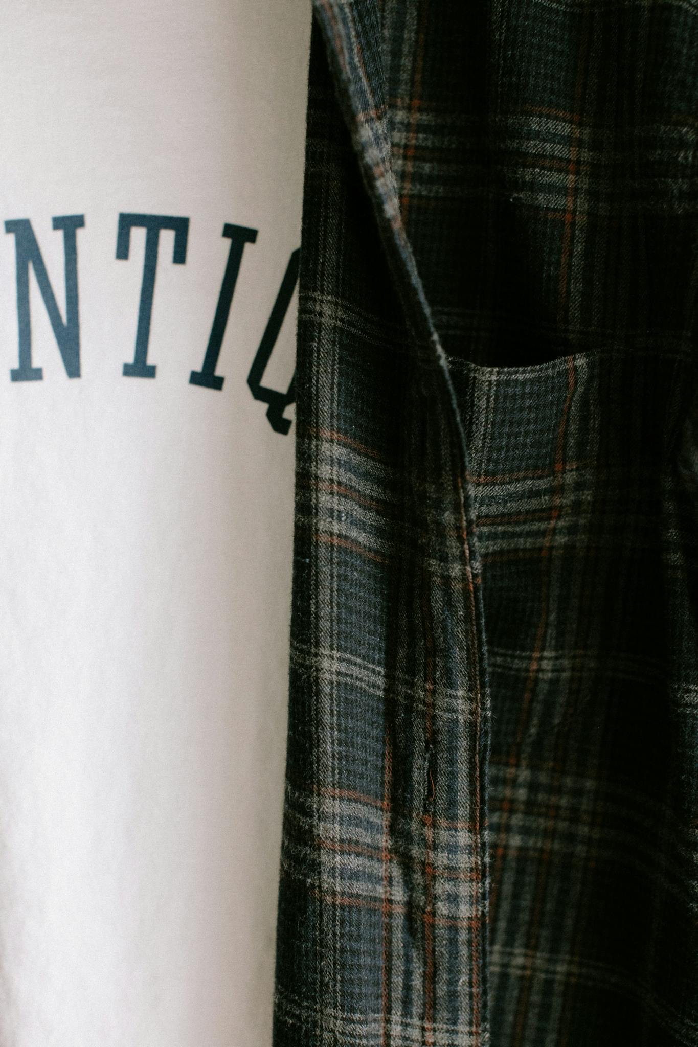 A detailed close-up of a flannel shirt over a printed t-shirt, perfect for fashion or lifestyle themes.